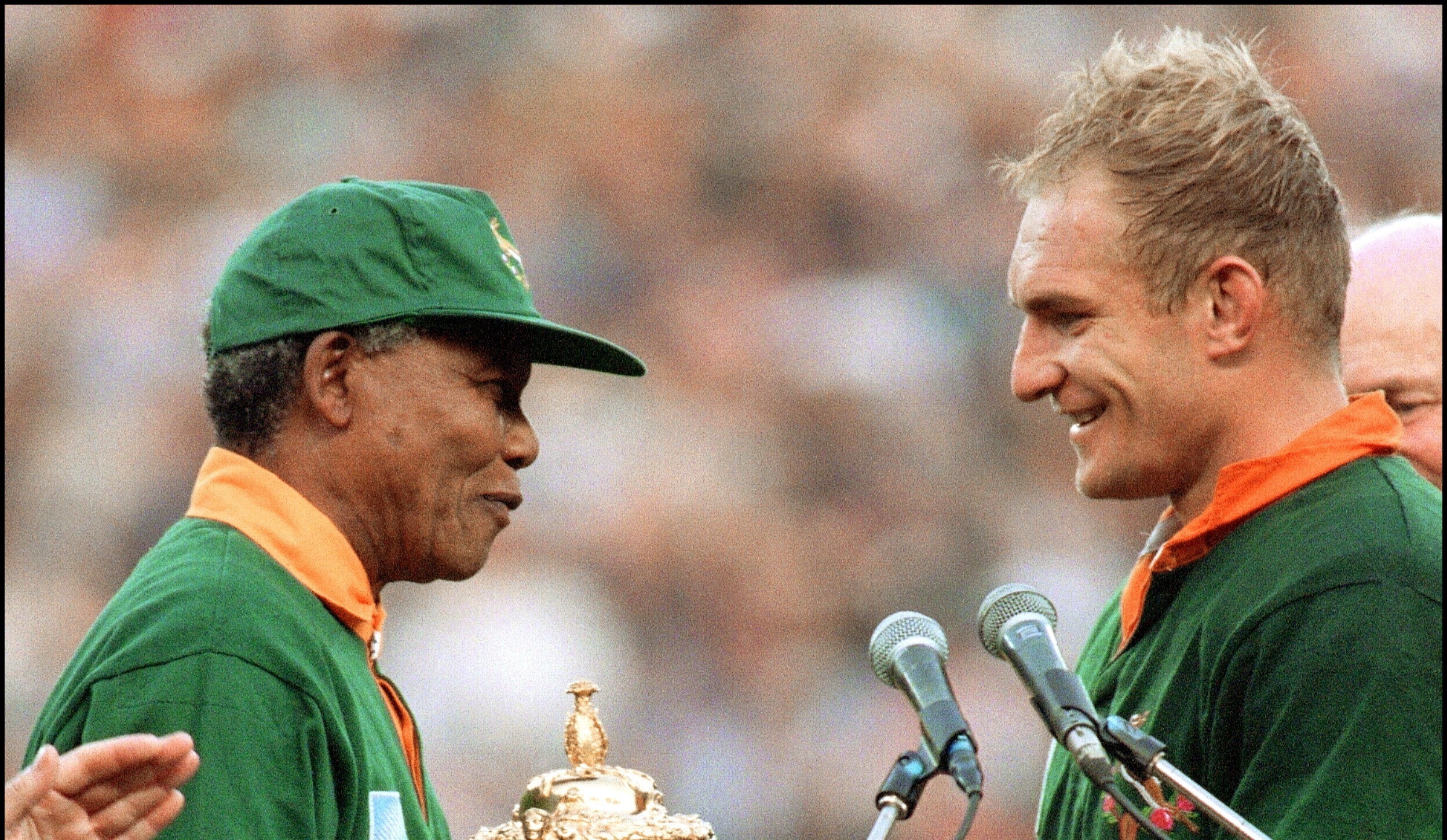 Güney Afrika ile Yeni Zelanda arasında oynanan 1995 Ragbi Dünya Kupası Finali'nin ardından takım kaptanı François Pienaar, Nelson Mandela'nın elinden kupayı alıyor.